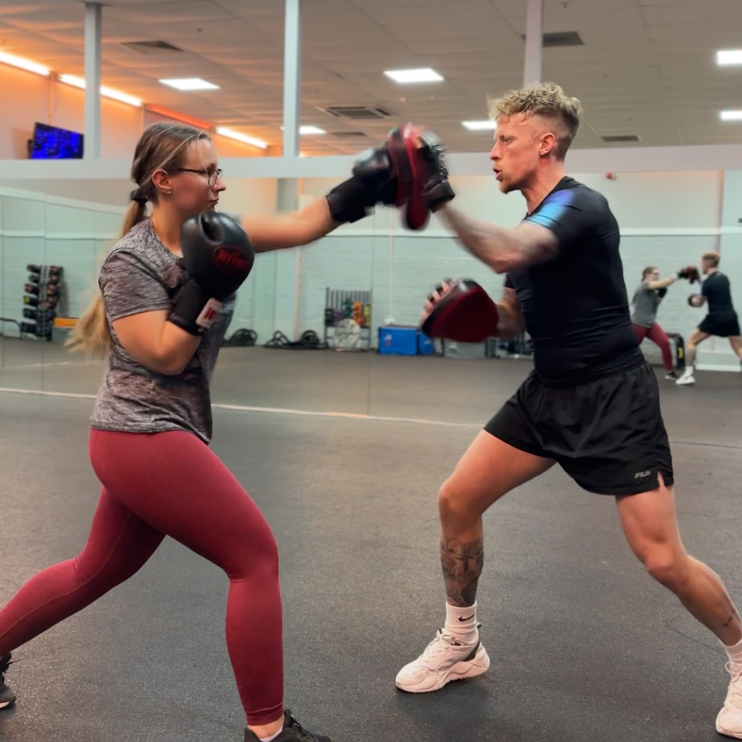 Jake coaching a client on the pads